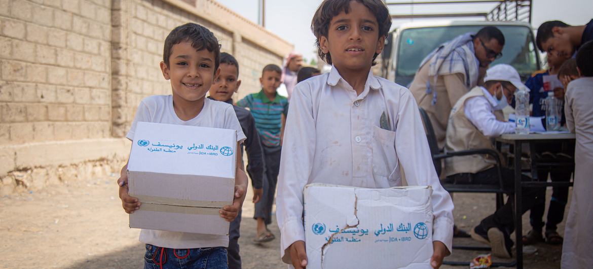 Displaced children carry hygiene kits distibuted by UNICEF in Marib, Yemen.